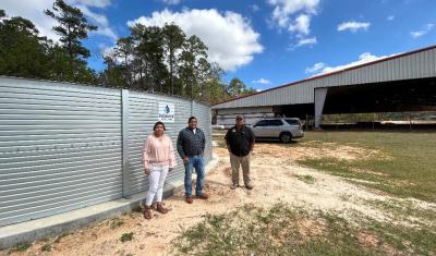 Right to Left; Gesse Bullock-Tribal Fire Management Specialist; Elliot Abbey-Deputy Tribal Administrator for Community Development; Selena Battise-Tribal Administrative Assistant who oversaw the installation of the 65,000-gallon storage tank seen in the foreground. Rainwater is harvested from the adjacent Veteran's Pavilion in the background.