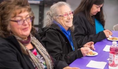 Three women enjoy a meal. 