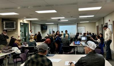 A room full of workshop participants chatting amongst each other before the days events begin.