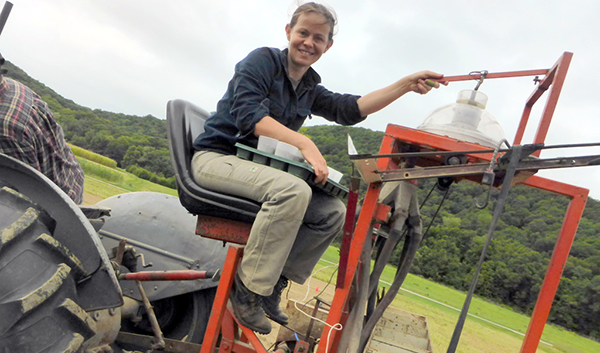 Katie seeding cover crops for a trial at the UMass research farm on the plot seeder grain drill