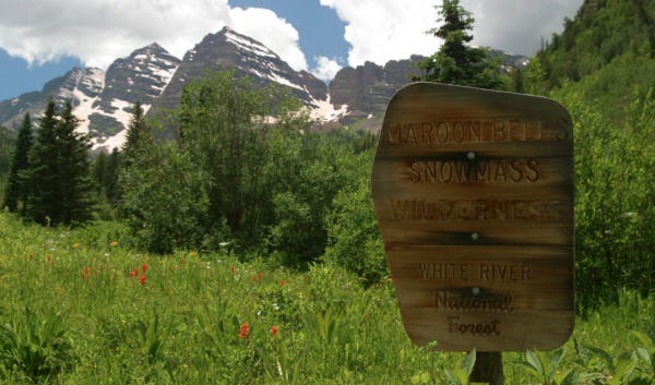 Wooden sign in front of Maroon Bells mountains